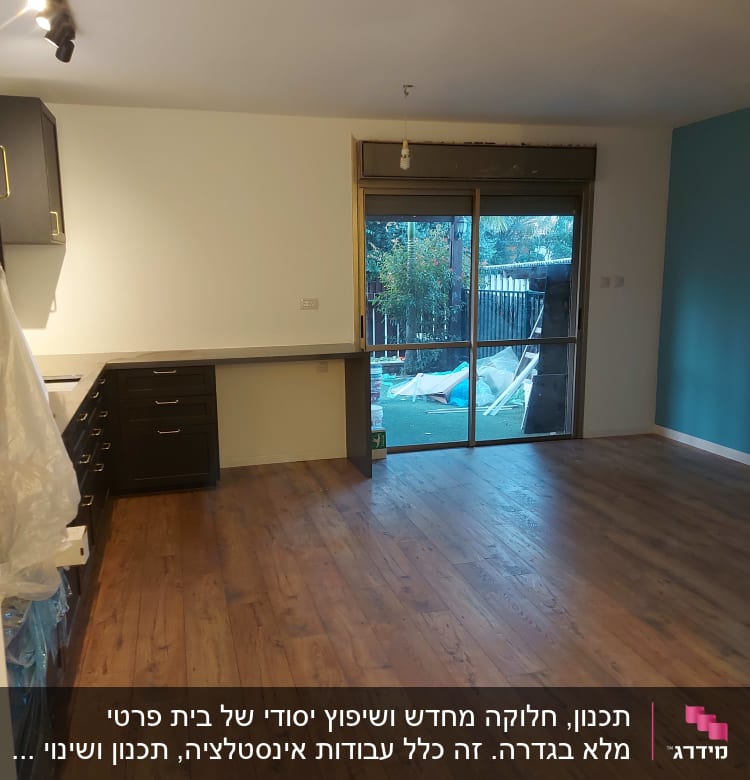 מטבח עם ארונות כהים ומשטח עבודה לבן